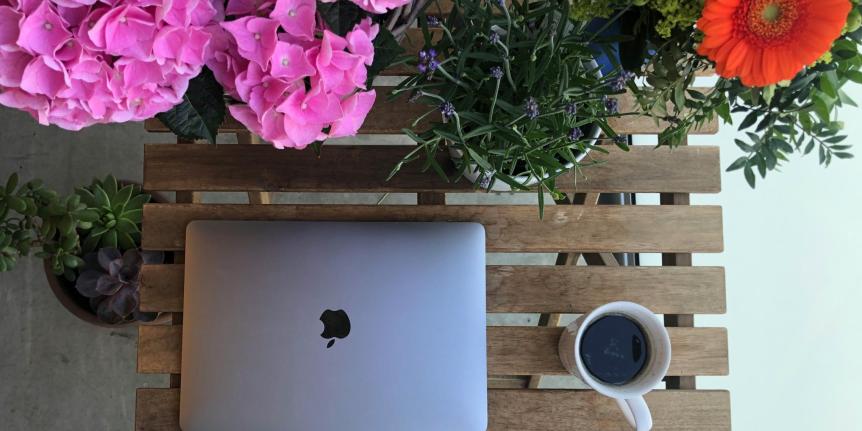 Computer with flowers next to it 