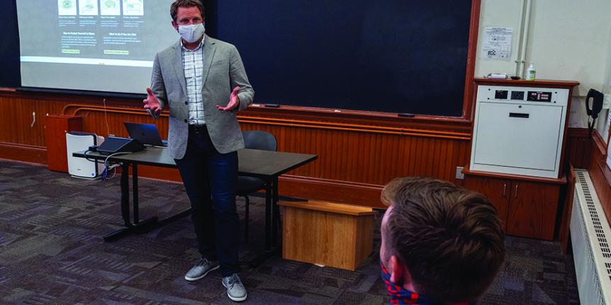 A masked professor teaching