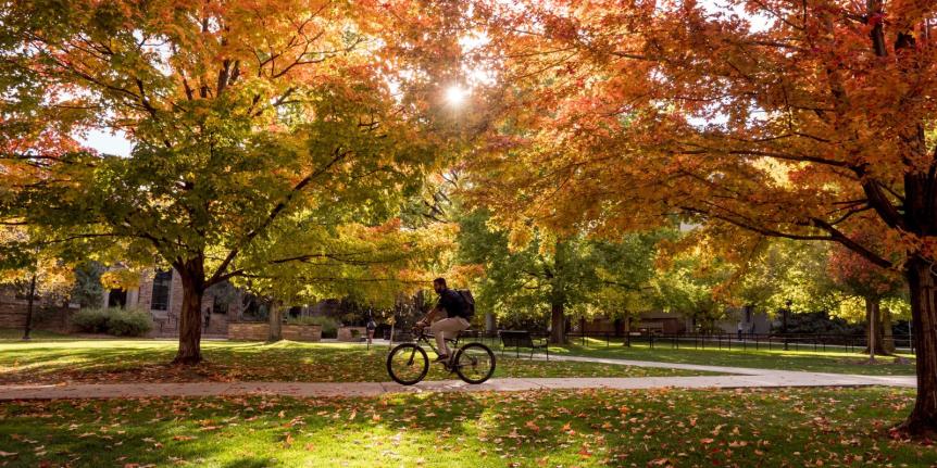 Fall campus photo of someone riding a bike