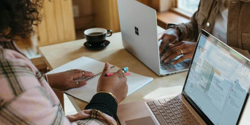 Two people studying with computers 