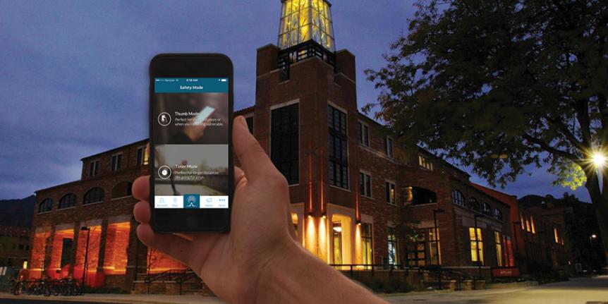 Hand holding a smartphone displaying the LifeLine app with the ATLAS building at night in the background.