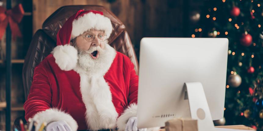 Santa looking at computer with surprised expression