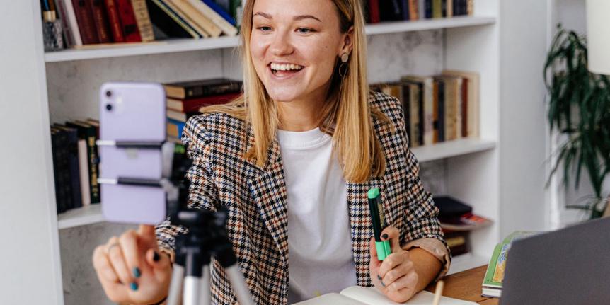 Decorative photo: someone uses a phone on tripod for a meeting.