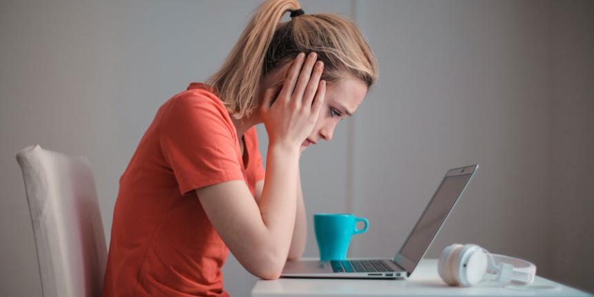 Young woman looks-worriedly at laptop computer.